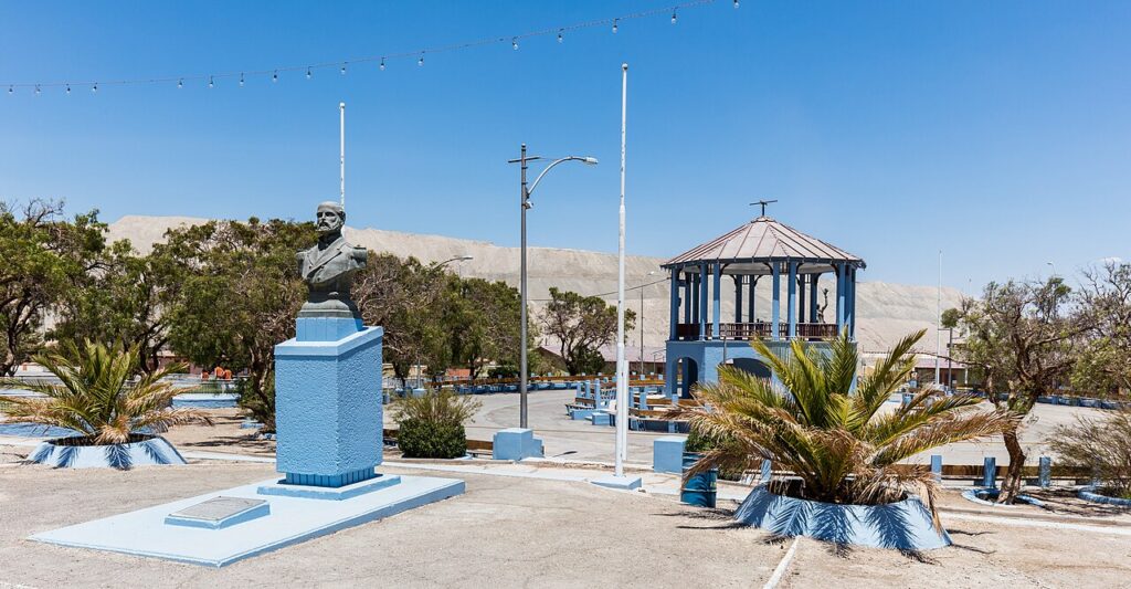 Calle del campamento de Chuquicamata con el botadero de la mina al fondo