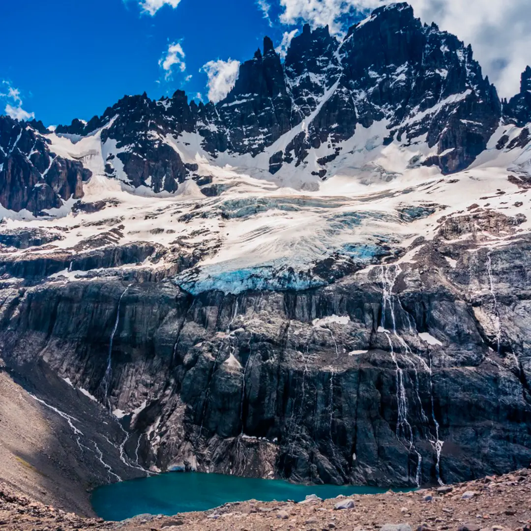 Cumbres rocosas del Cerro Castillo con un glaciar y una laguna turquesa