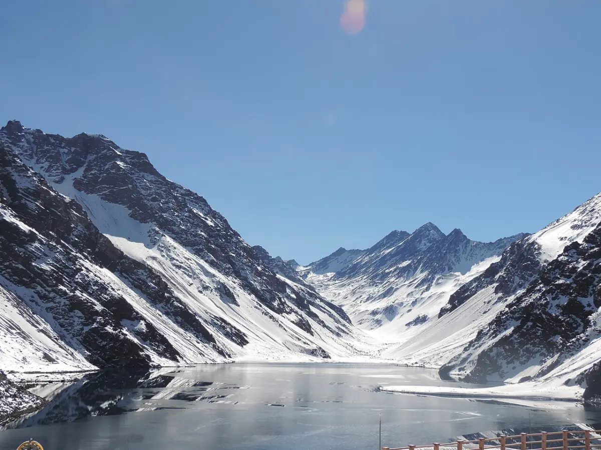 Orilla de la Laguna del Inca con montañas de roca alrededor, en Portillo