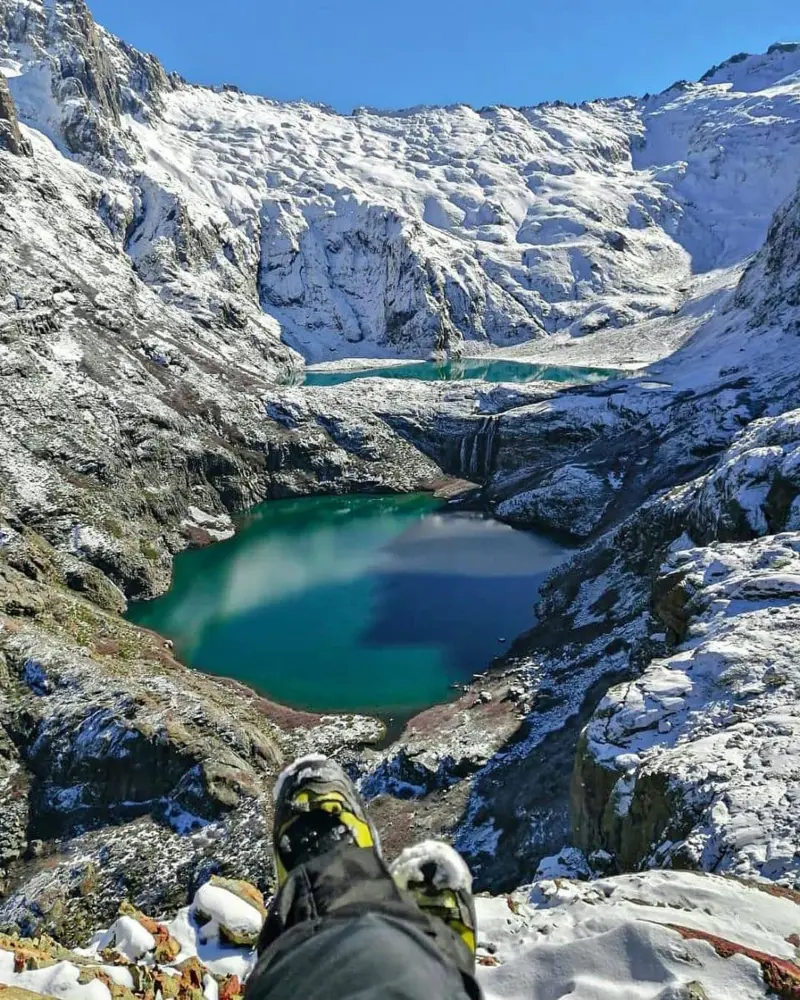Laguna de aguas turquesa entre cumbres nevadas en la cordillera del Maule