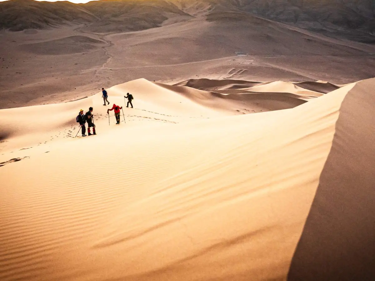 Excursionistas subiendo una duna del Mar de Dunas cerca de Copiapó