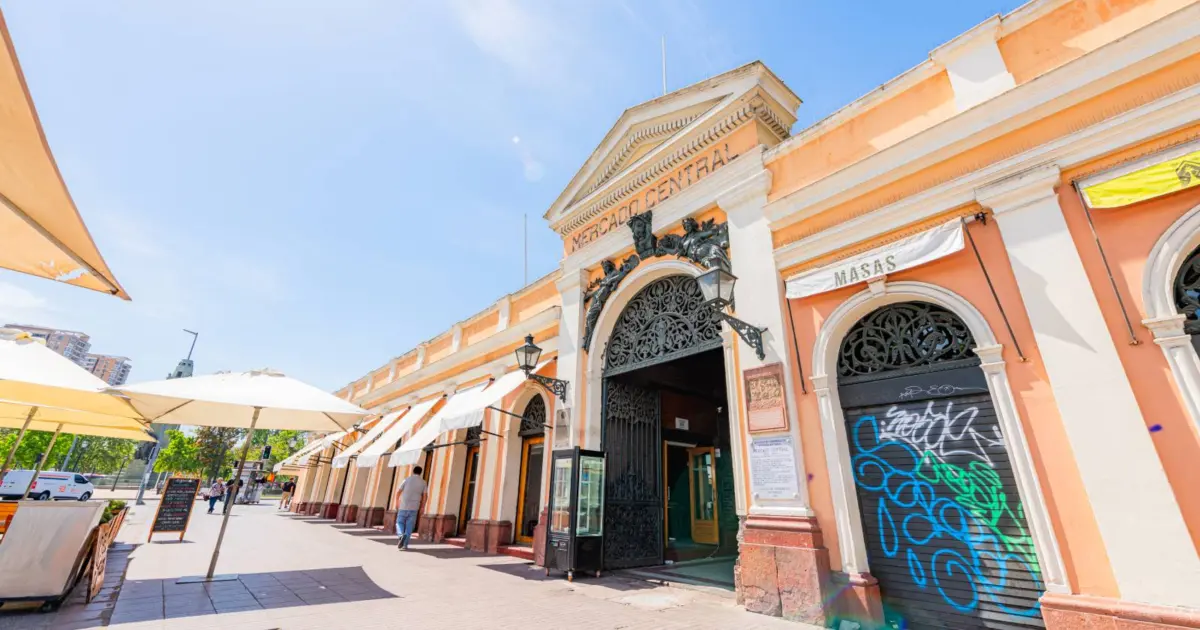 Fachada del Mercado Central de Santiago con toldos y mesas en la calle