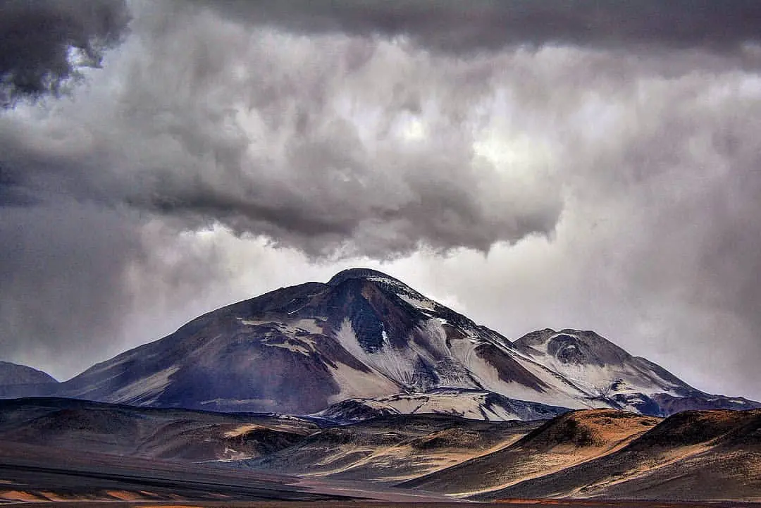 Volcán Ojos del Salado bajo un cielo cubierto de nubes oscuras