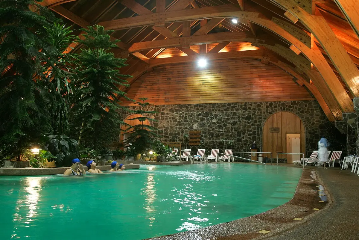 Piscina techada de aguas termales con techo de madera en el complejo de las Termas de Puyehue