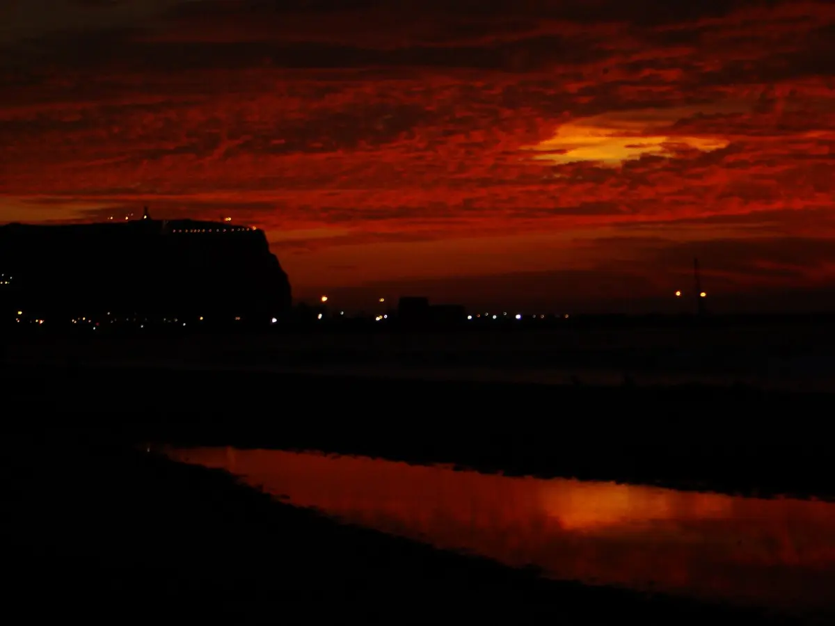 Extensa playa Chinchorro en Arica con arena oscura y oleaje suave