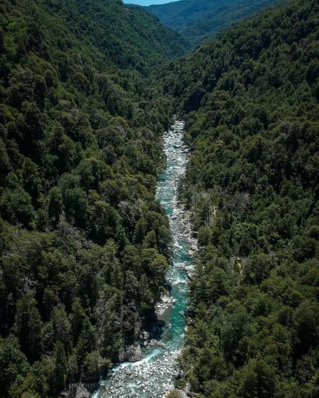 Río de aguas claras entre laderas cubiertas de bosque nativo en el sur de Chile