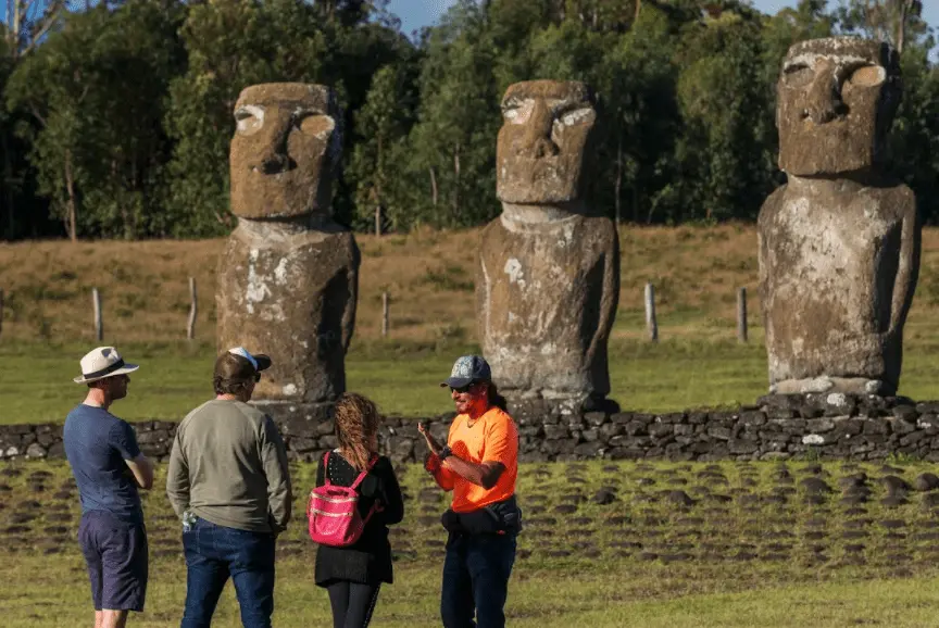 Visitantes frente a moai en la isla de Rapa Nui