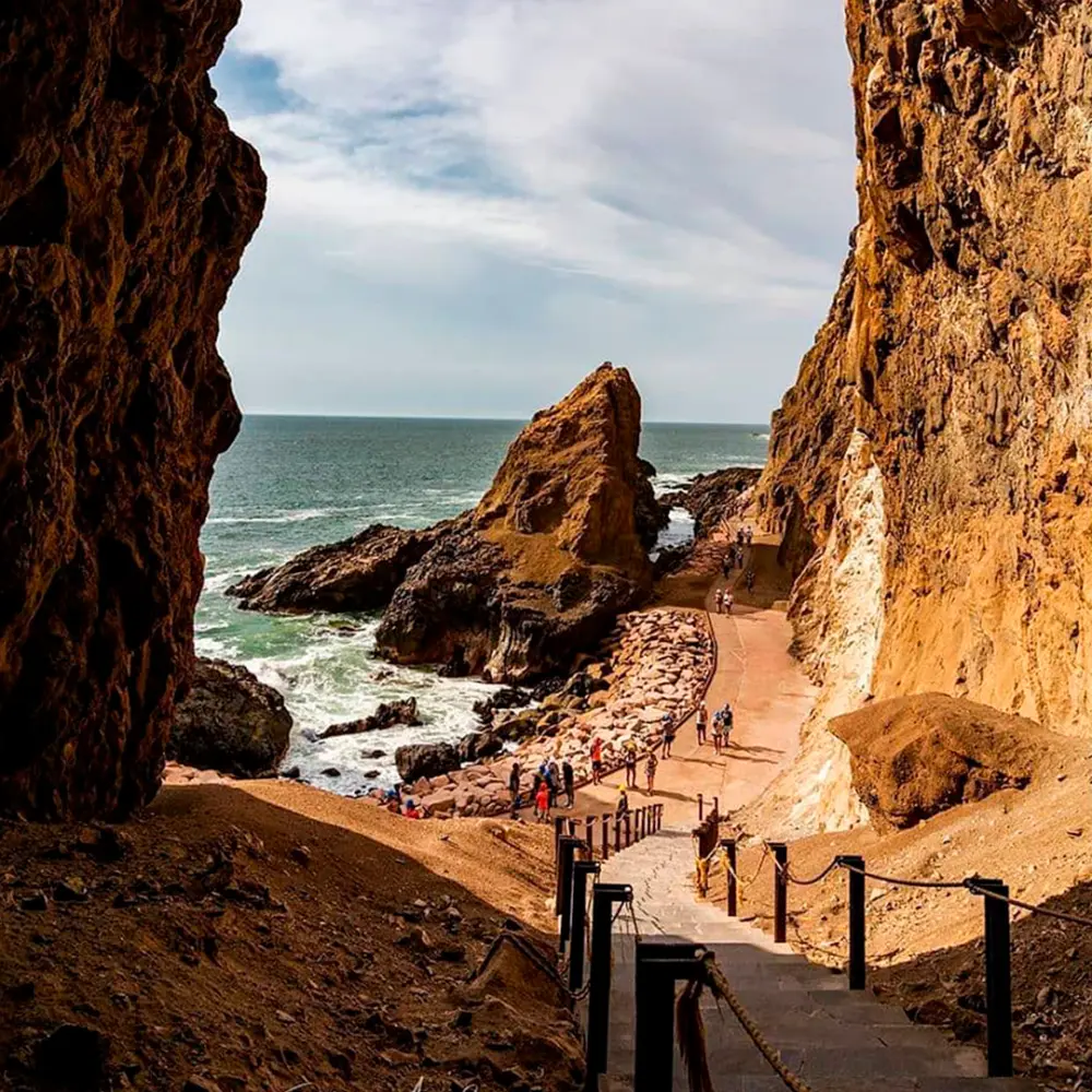 Sendero entre rocas hacia el mar en las cuevas de Anzota, en Arica