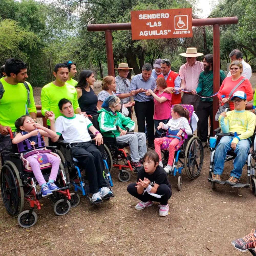 Grupo de visitantes, algunos en silla de ruedas, frente al sendero inclusivo Las Águilas en la Reserva Nacional Río de los Cipreses