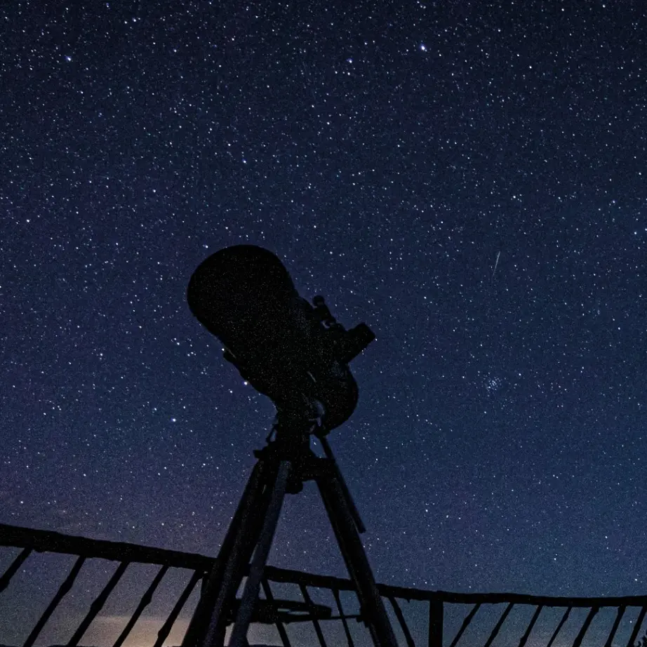 Telescopio bajo un cielo estrellado durante un tour astronómico con enfoque mapuche